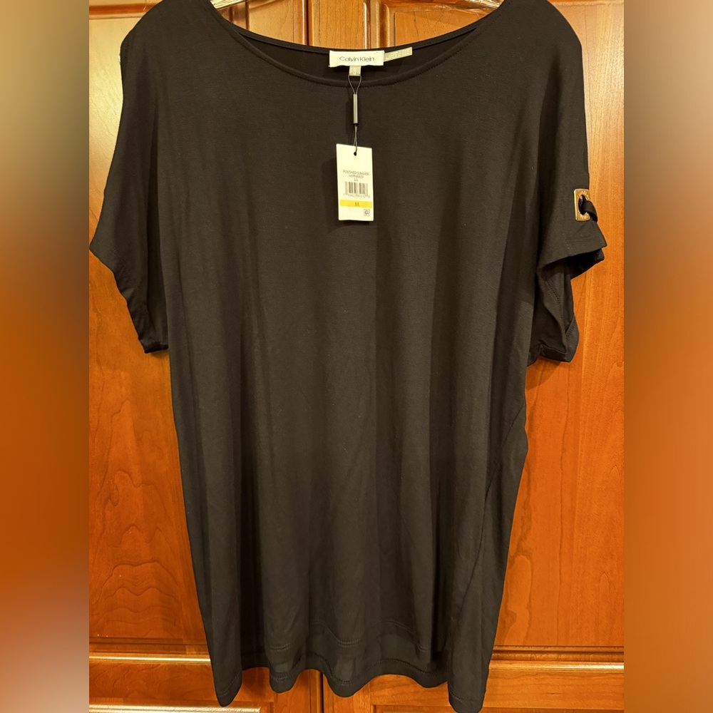 Black with gold on sleeve .Calvin Klein top. Size Medium. Cold shoulder.